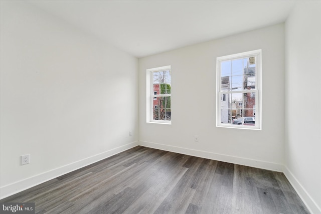 unfurnished room with dark wood-type flooring