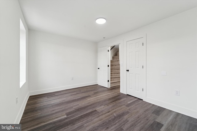 unfurnished room with dark wood-type flooring