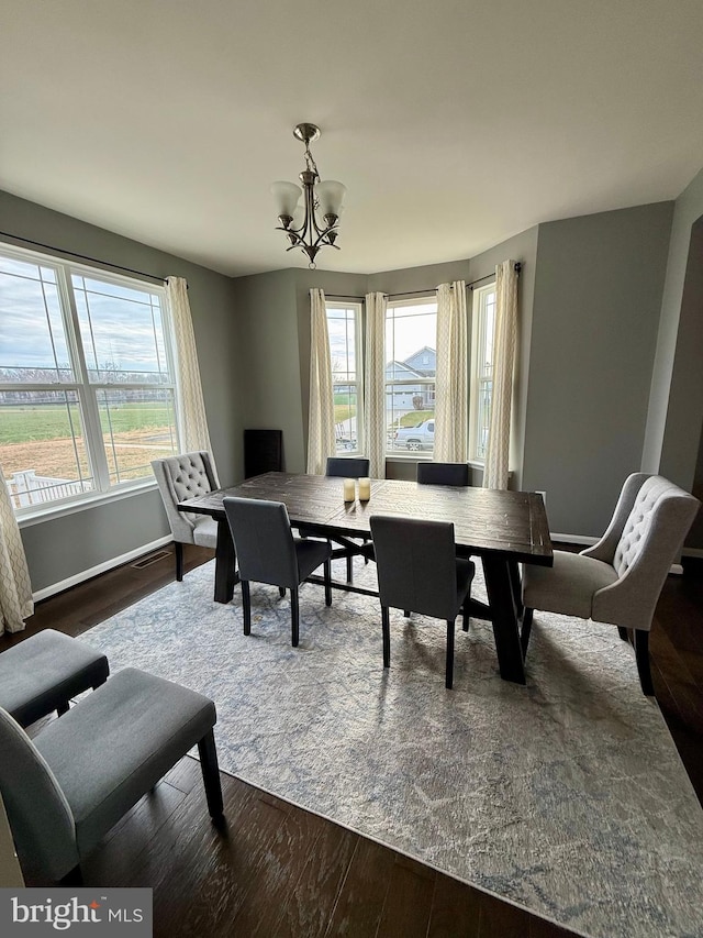 dining area with a chandelier, hardwood / wood-style floors, and a healthy amount of sunlight