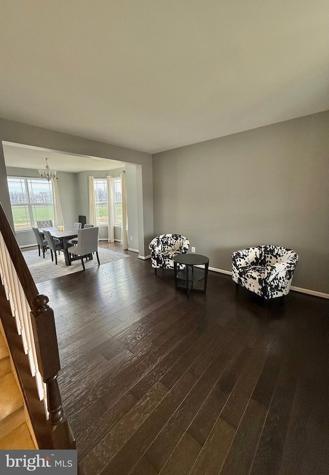 unfurnished room with wood-type flooring and an inviting chandelier