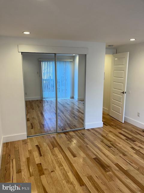 unfurnished bedroom featuring hardwood / wood-style flooring and a closet