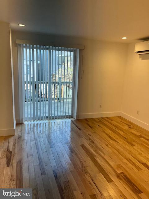 empty room with hardwood / wood-style flooring and a wall mounted AC