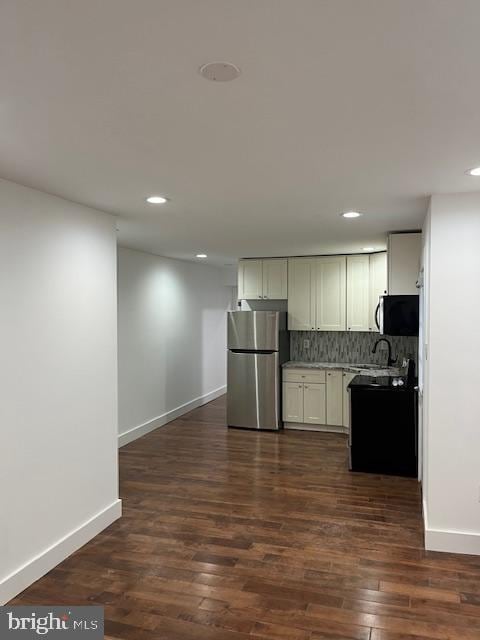 kitchen featuring appliances with stainless steel finishes, dark hardwood / wood-style flooring, tasteful backsplash, and white cabinetry