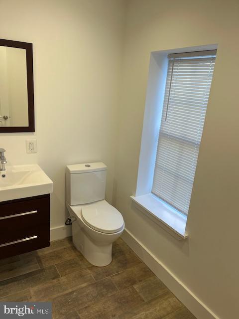 bathroom featuring hardwood / wood-style flooring, vanity, and toilet