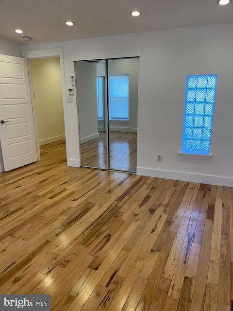 unfurnished bedroom with a closet and light wood-type flooring