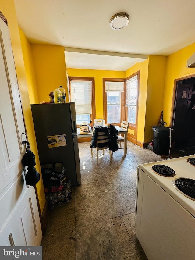 kitchen featuring electric range and stainless steel refrigerator