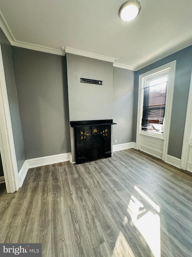 unfurnished living room featuring crown molding and hardwood / wood-style flooring