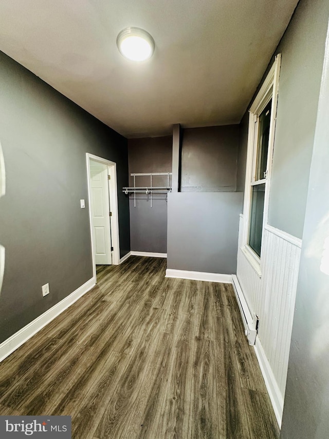 interior space featuring baseboard heating, a closet, and dark hardwood / wood-style floors