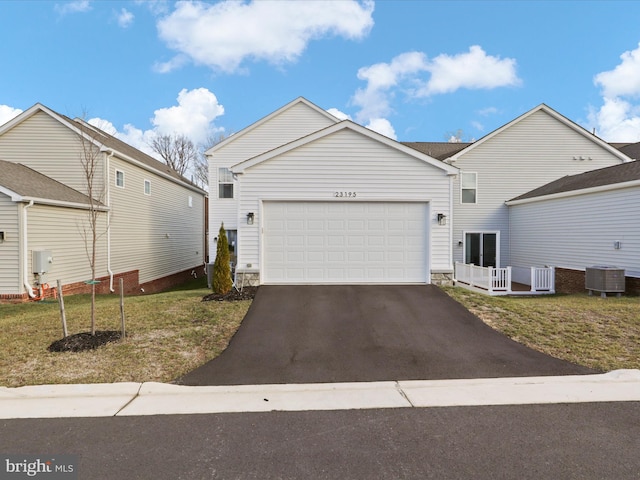 view of front of house featuring a front yard, a garage, and cooling unit