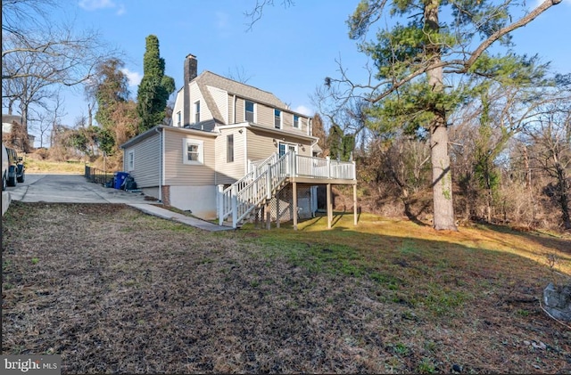 rear view of house featuring a patio area, a deck, and a yard