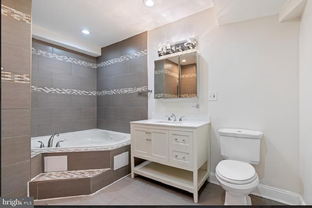 bathroom featuring tile patterned floors, tiled tub, vanity, and toilet