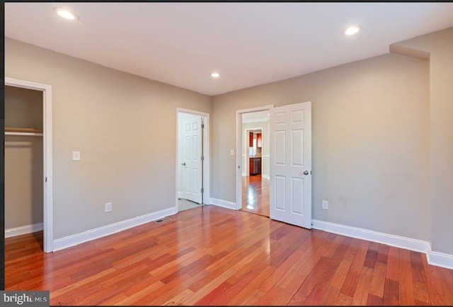 unfurnished bedroom featuring wood-type flooring and a closet