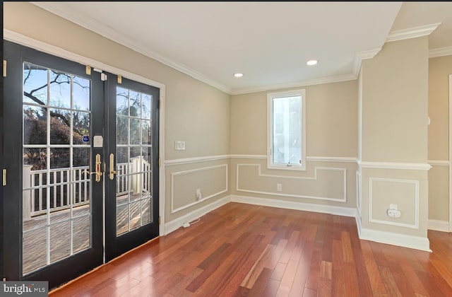 interior space featuring wood-type flooring, ornamental molding, and french doors