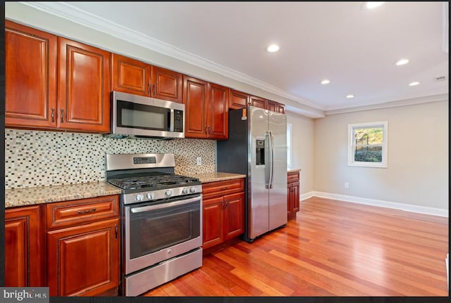 kitchen with light stone countertops, crown molding, stainless steel appliances, and light wood-type flooring