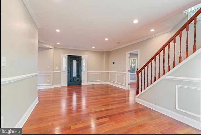 foyer entrance with light hardwood / wood-style flooring and ornamental molding