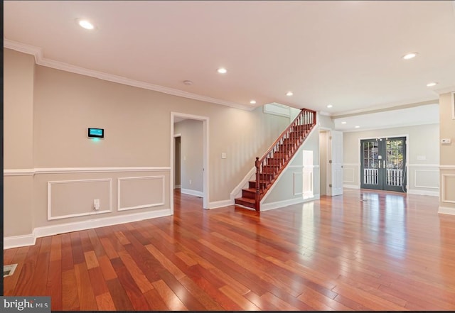 spare room featuring crown molding, light hardwood / wood-style flooring, and french doors