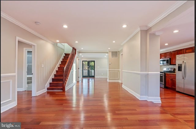 interior space with hardwood / wood-style floors, crown molding, and french doors