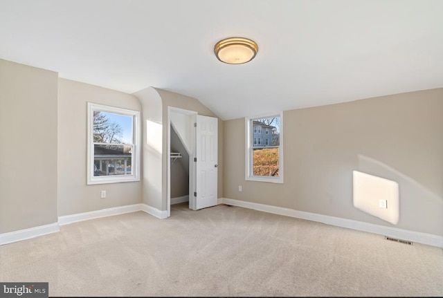 additional living space with lofted ceiling and light carpet