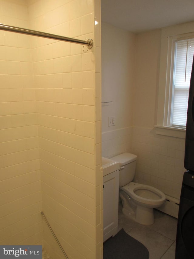 bathroom with tile patterned flooring, tile walls, and toilet