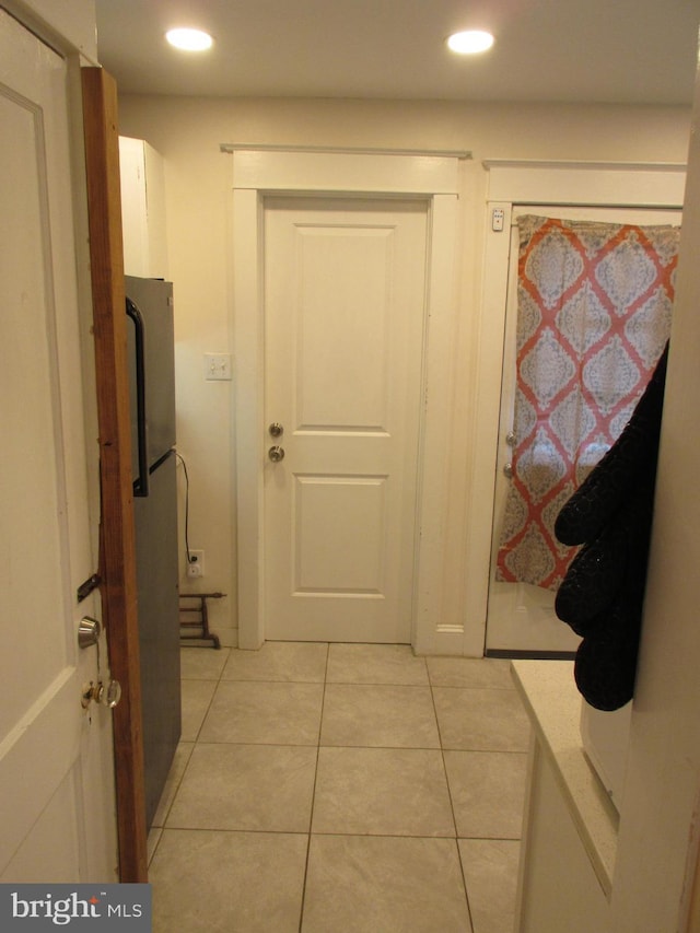 hall with light tile patterned floors