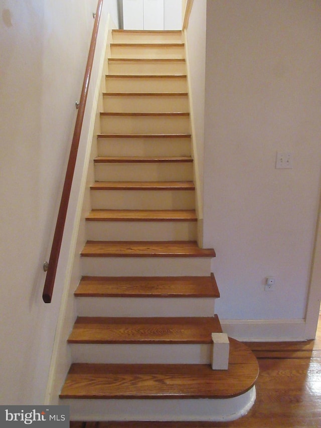 stairs featuring hardwood / wood-style floors