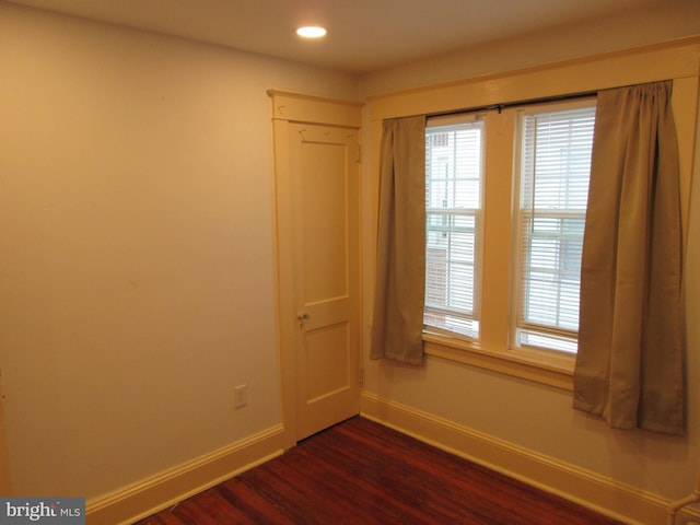 spare room with dark wood-type flooring