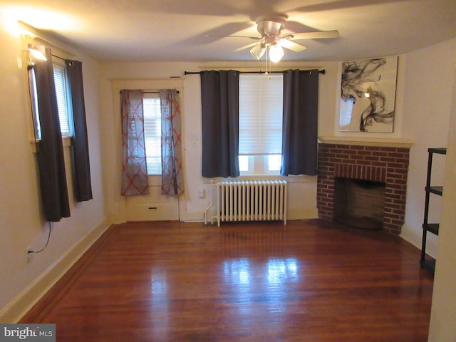 unfurnished living room with radiator heating unit, dark hardwood / wood-style floors, plenty of natural light, and ceiling fan