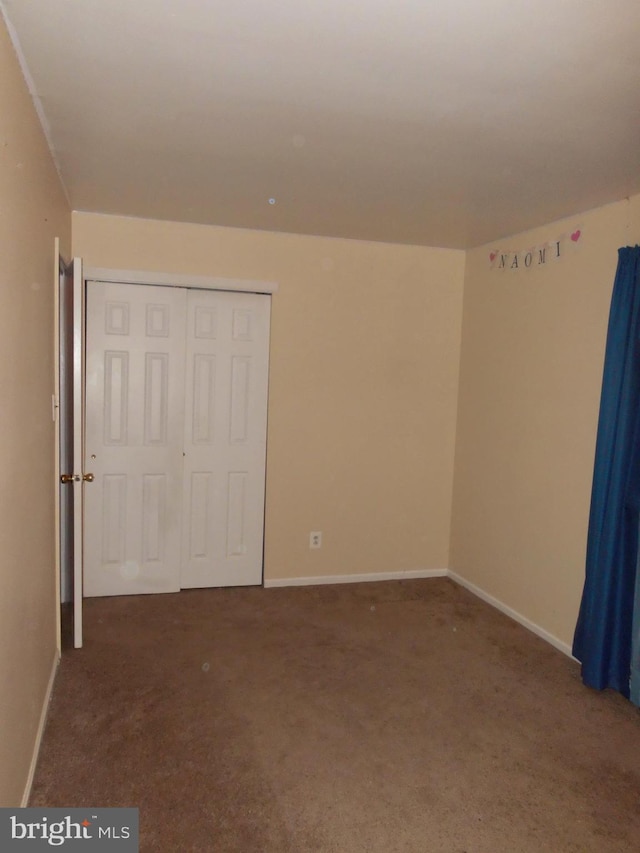 unfurnished bedroom featuring a closet and carpet flooring