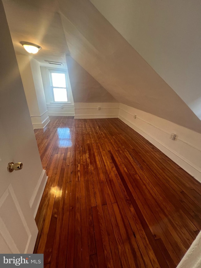 additional living space with hardwood / wood-style flooring and lofted ceiling