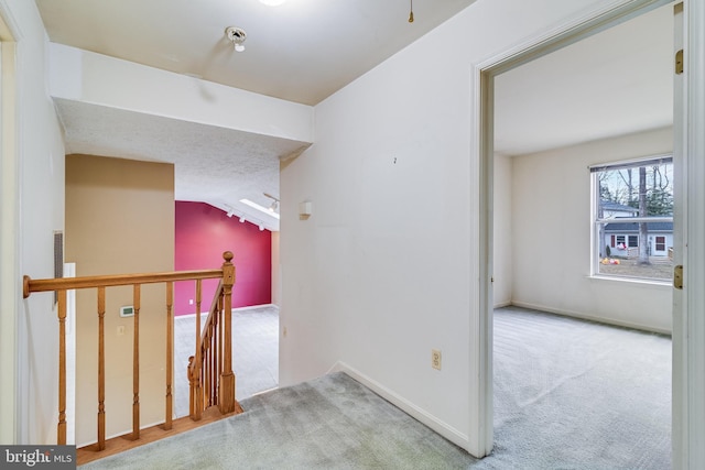 corridor featuring lofted ceiling and light carpet