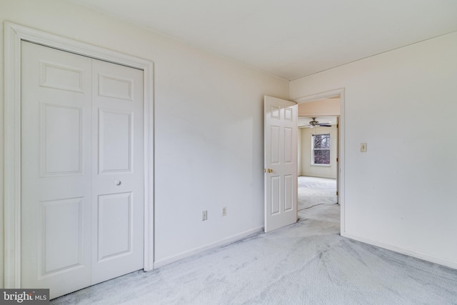 unfurnished bedroom featuring light colored carpet and a closet