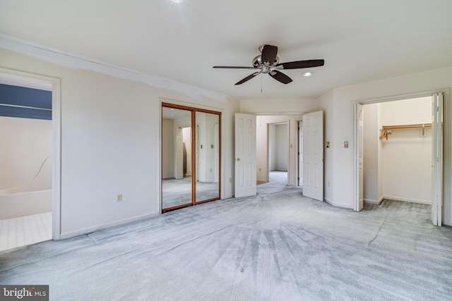 unfurnished bedroom with ceiling fan, ensuite bathroom, and light carpet