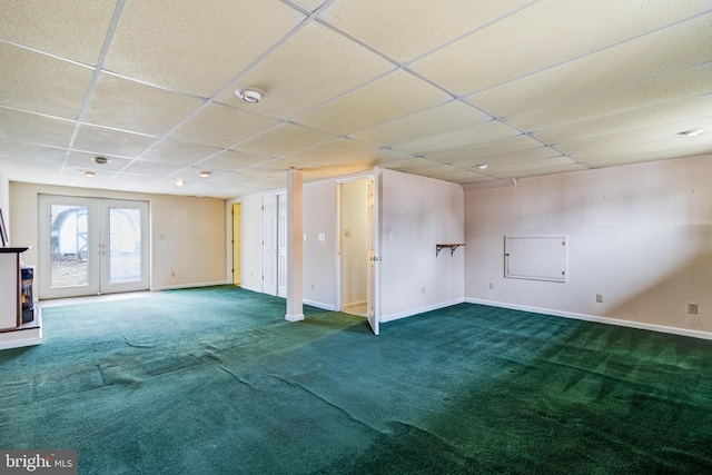 basement with carpet flooring, a drop ceiling, and french doors