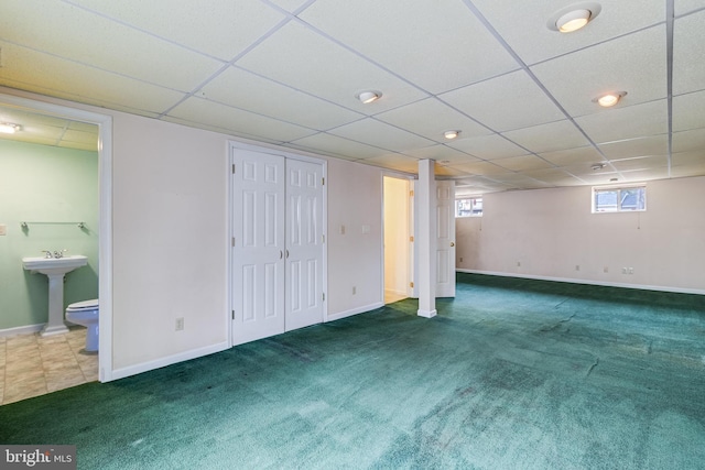 basement featuring sink and dark colored carpet