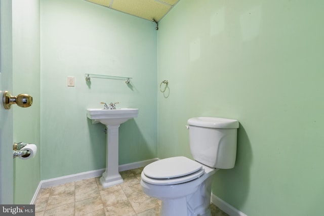 bathroom with toilet and a drop ceiling