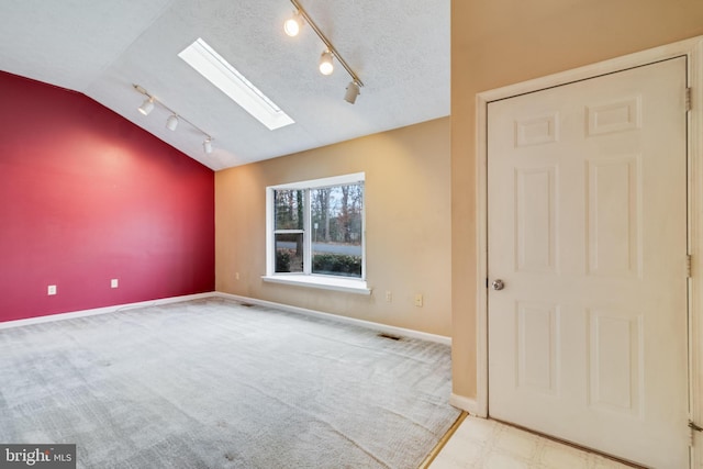 empty room with lofted ceiling with skylight