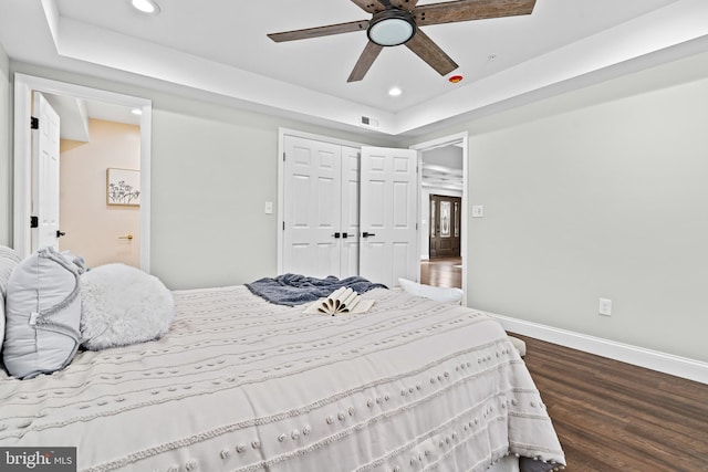 bedroom with dark hardwood / wood-style flooring, a closet, and ceiling fan