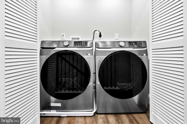 washroom with dark hardwood / wood-style floors and washing machine and dryer