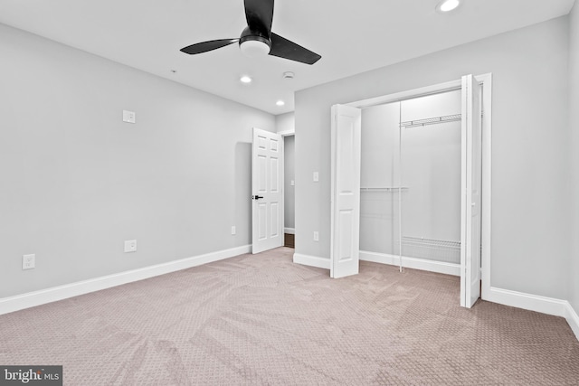 unfurnished bedroom featuring ceiling fan, light carpet, and a closet