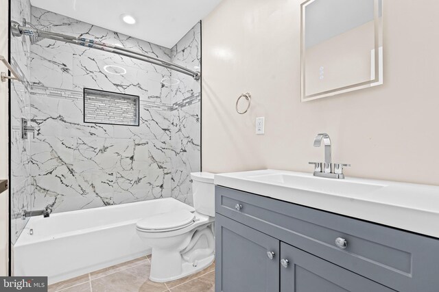 full bathroom featuring tile patterned floors, vanity, toilet, and tiled shower / bath combo