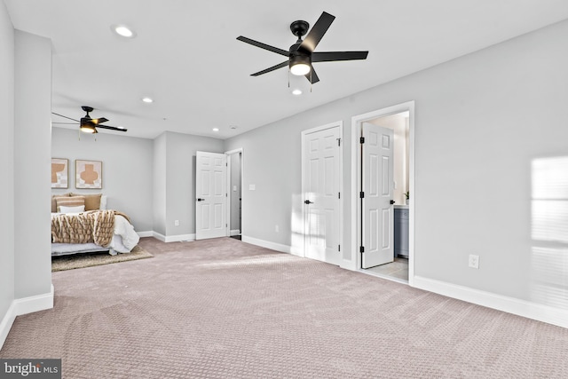 unfurnished bedroom with connected bathroom, light colored carpet, and ceiling fan