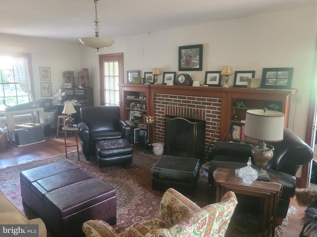 living room with a healthy amount of sunlight, wood-type flooring, and a fireplace