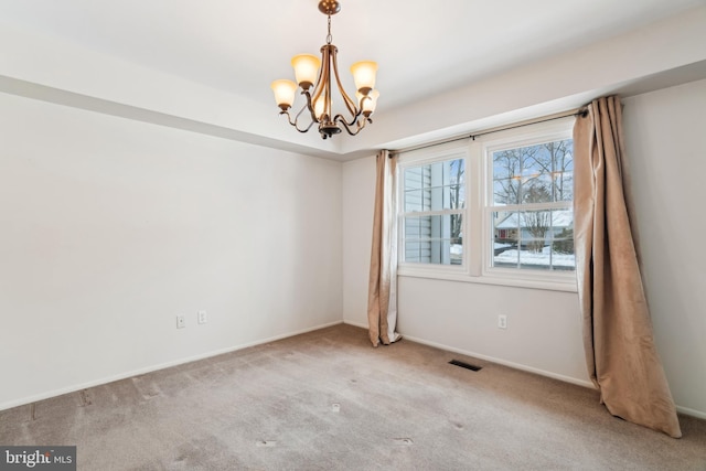 carpeted empty room with a notable chandelier