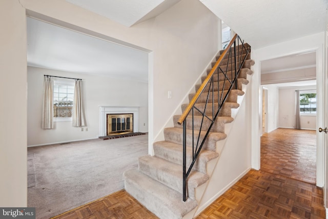 stairs featuring parquet floors and plenty of natural light