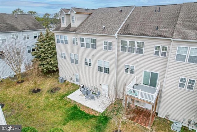 back of property with a yard, a patio area, and central air condition unit