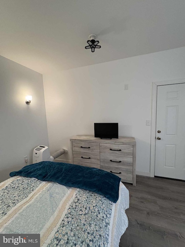 bedroom with dark wood-type flooring