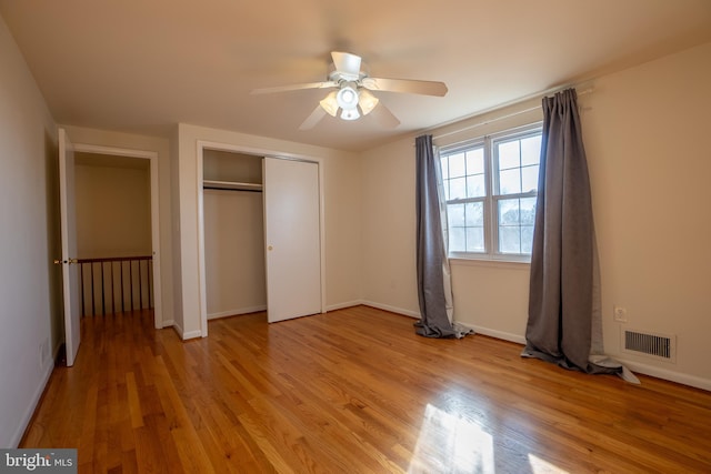 unfurnished bedroom with a closet, light hardwood / wood-style flooring, and ceiling fan