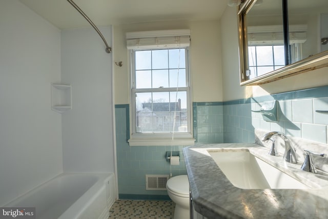 full bathroom with tile patterned flooring, a healthy amount of sunlight, tile walls, and bathtub / shower combination