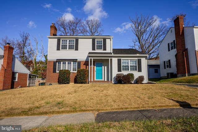 view of property featuring a front yard and central AC