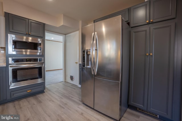 kitchen featuring gray cabinets, light hardwood / wood-style flooring, and stainless steel appliances